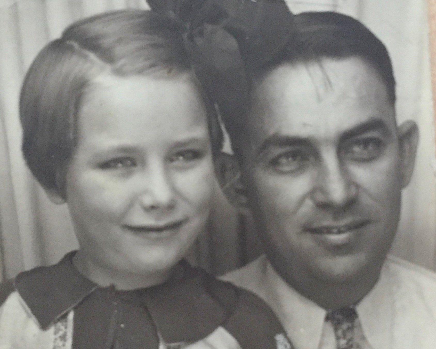 Vintage black-and-white photograph of a young girl and her father (or older man).