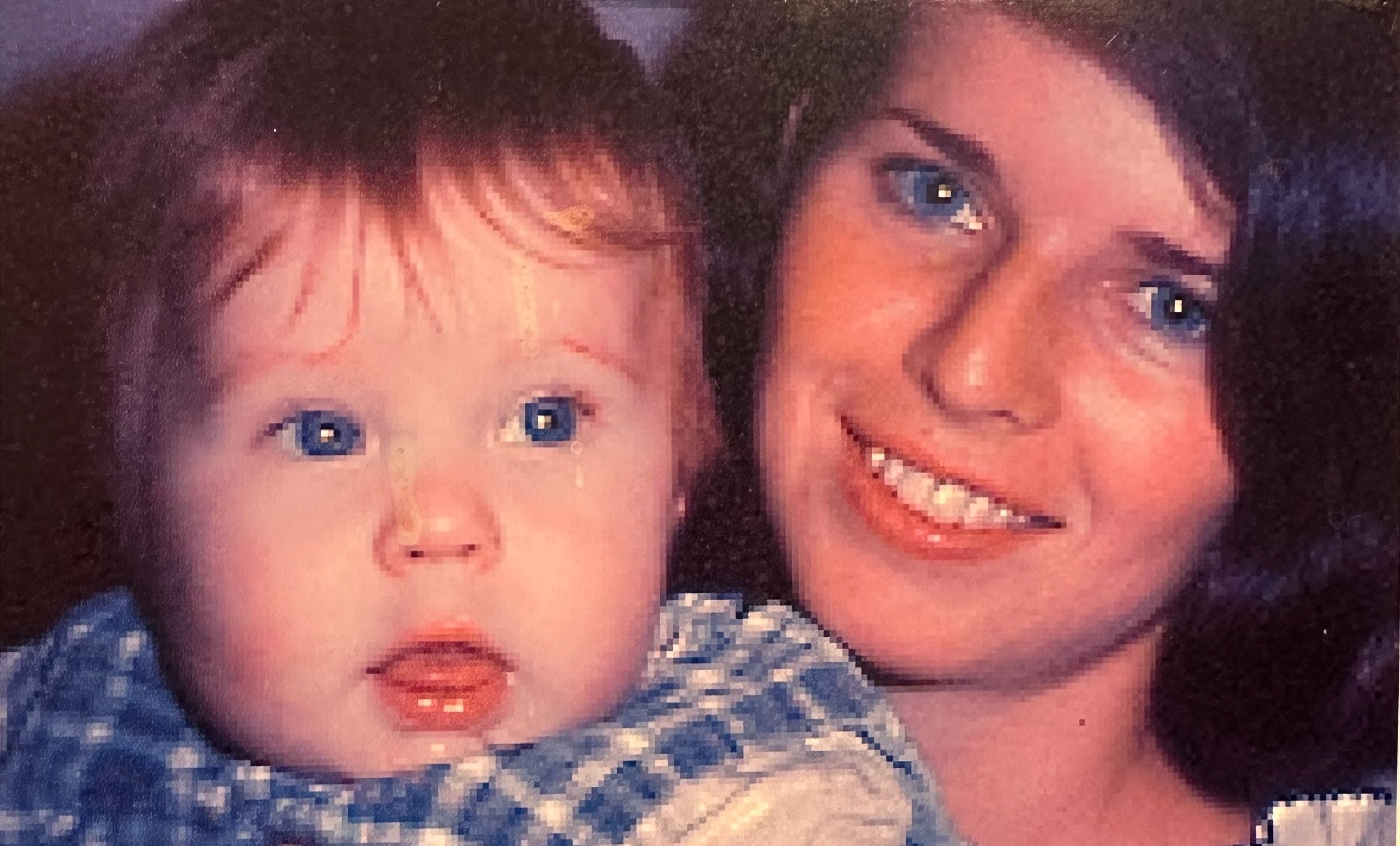 Close-up photograph of a mother and her young, blue-eyed baby.