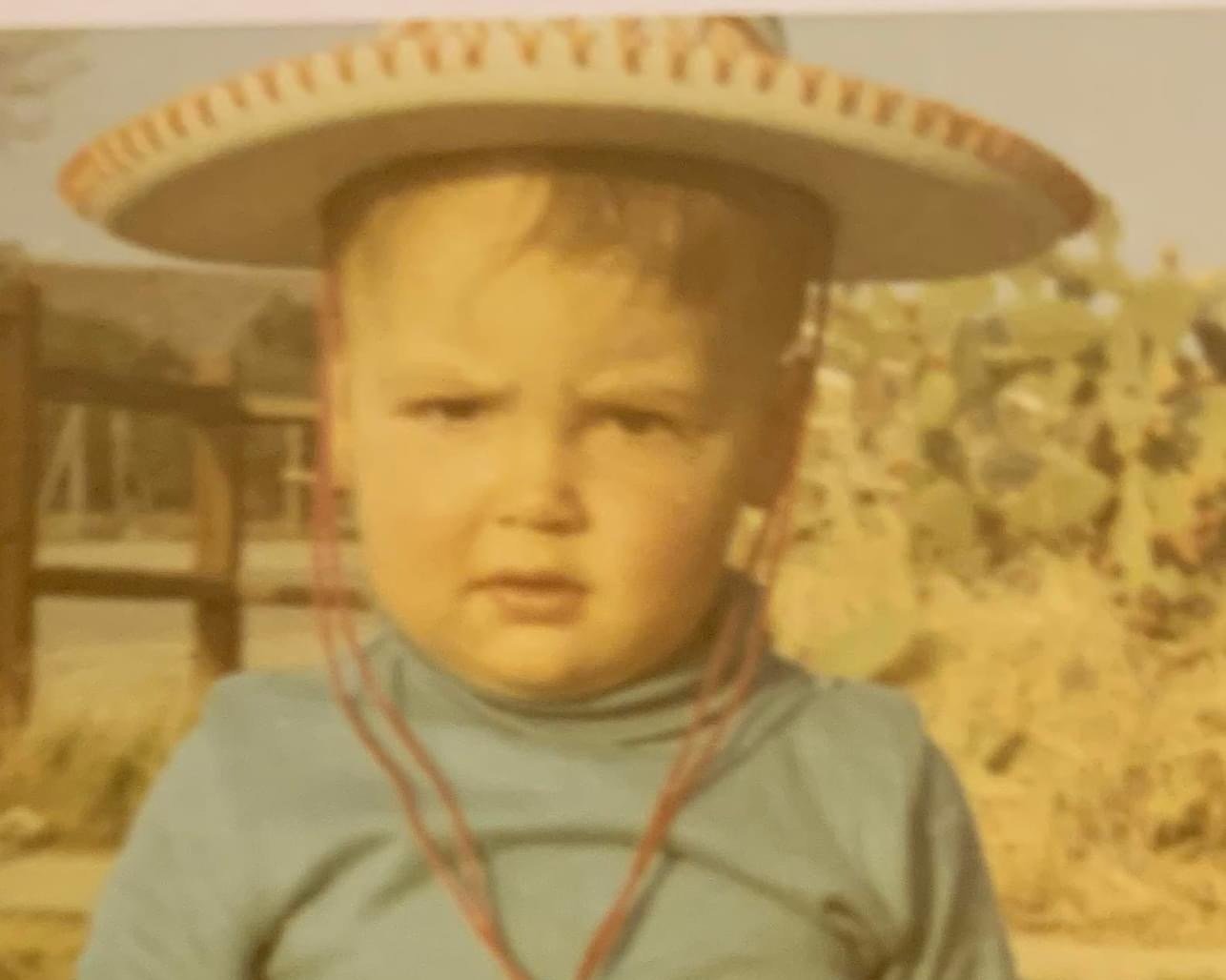Vintage photo of a small child wearing a large sombrero.